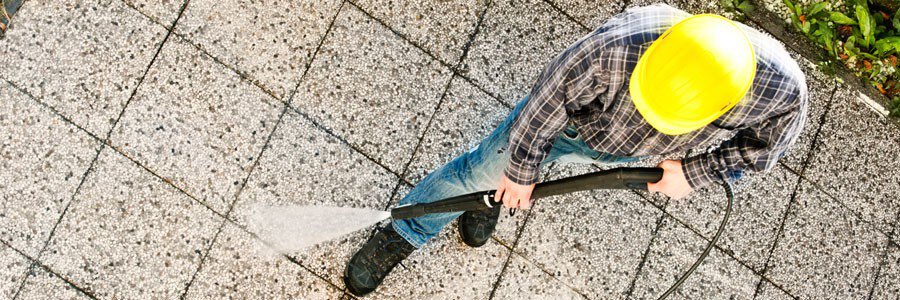 a worker pressure washing the gravel