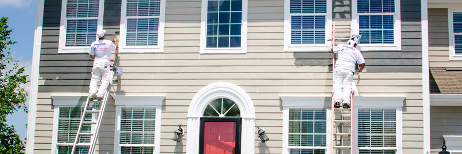 two painters painting the exterior gray